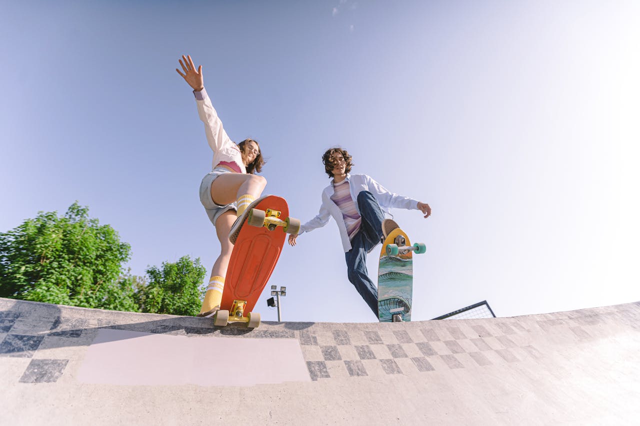 Two skateboarders in action at a skate park, captured with a low angle perspective, embodying youth and excitement.